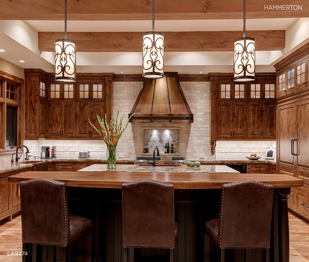 A trio of Chateau LA9274 pendants featuring delicate scrollwork and a Tuscan Arbor finish tie together subtle old-world details in this Canadian kitchen.