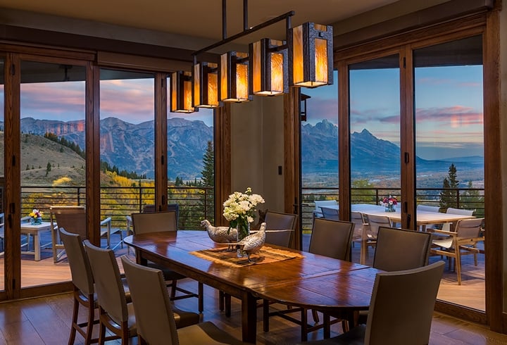 A custom Hammerton contemporary dining light in dark art glass and hammered steel enhances the sweeping postcard view of this Wyoming dining room | Trynity DeVries Interior Design | Bozeman, MT
