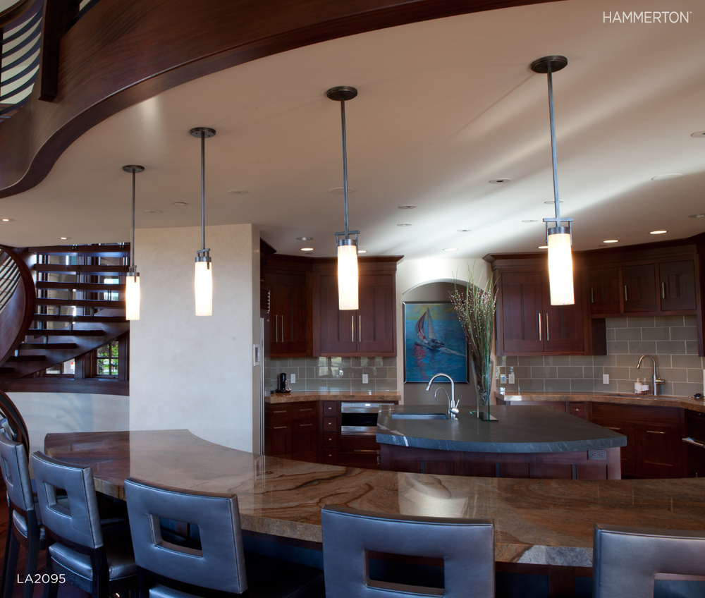 Contemporary LA2095 pendants in light blown glass allow the bold architecture surrounding this kitchen to take center stage. Interiors by Leslie Schofield Design.