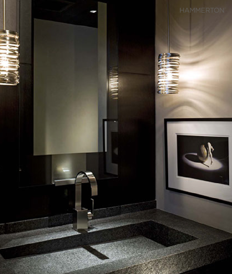 A pair of custom Lightspann pendants in this monochromatic powder room adds a touch of modern drama.