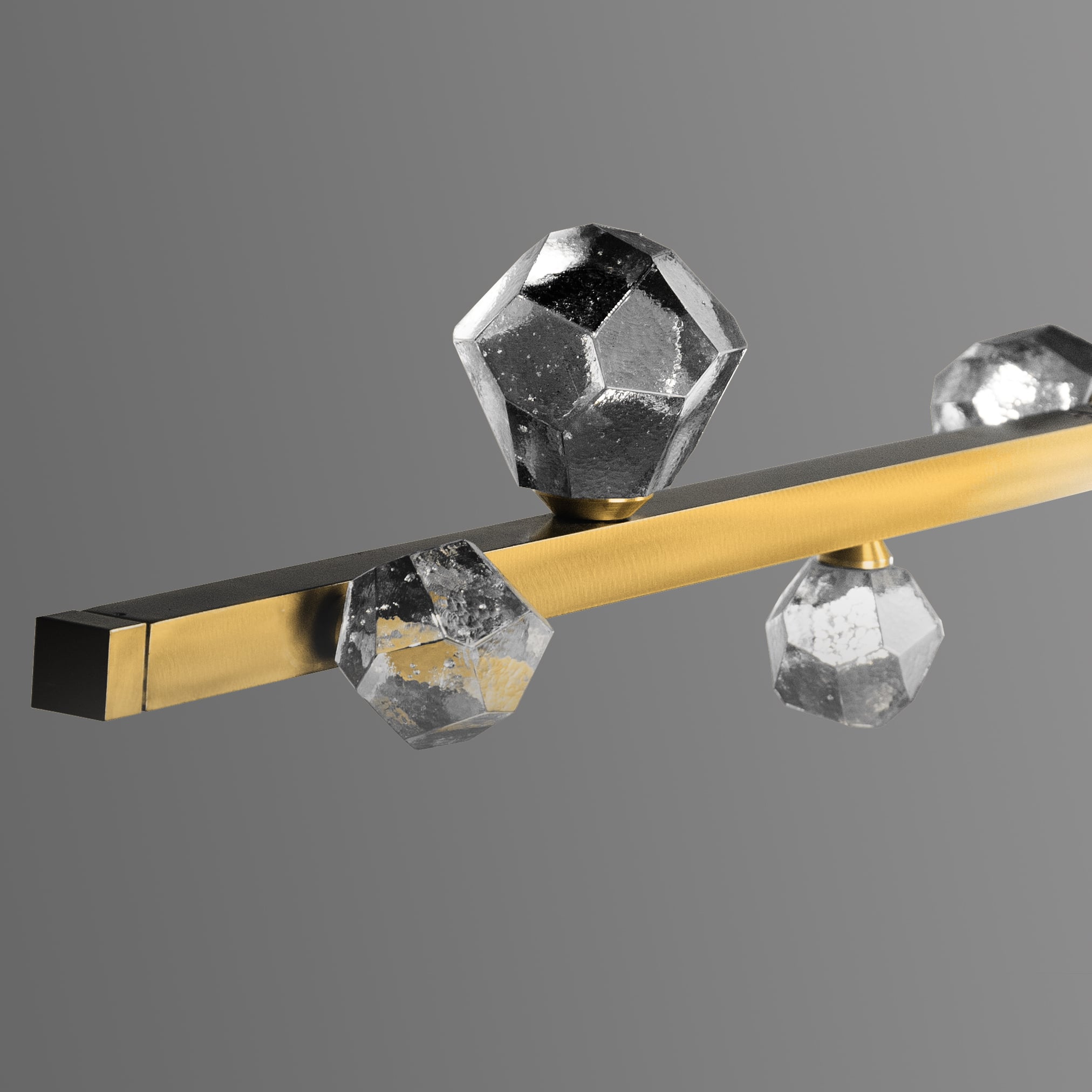 Closeup detail of a Hammerton Studio Stella rectangular chandelier focusing on the crystal glass gem-shaped bulbs on this minimalistic modern light fixture