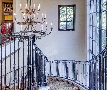 A graceful Chateau chandelier perfectly complements this stately European-style staircase. Architecture & interiors by Duvall Architects.