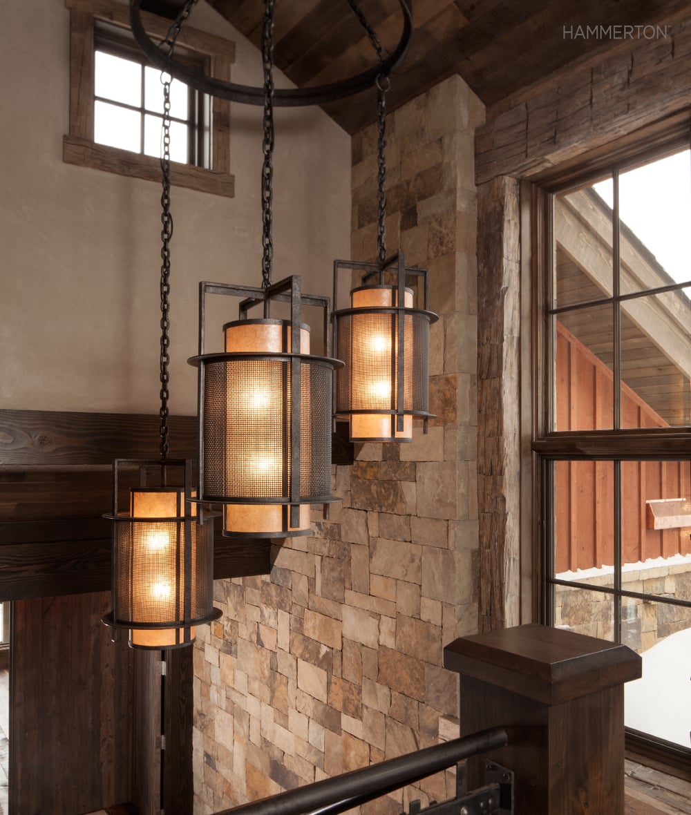 A Contemporary Craftsman-style waterfall chandelier provides a welcome counterpoint to the heavy finishes in this dramatic stairwell. Interiors by AP Resort Concepts.