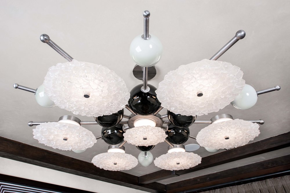 Detail image of the whimsical flush mount chandelier featuring several forms, textures, and glass styles by Hammerton
