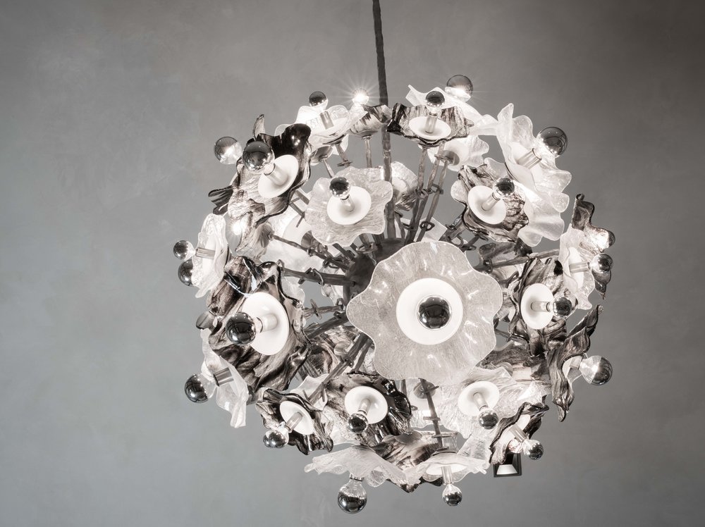 Detail of a spherical starburst chandelier featuring layers of glass and metal discs to create an unique look.
