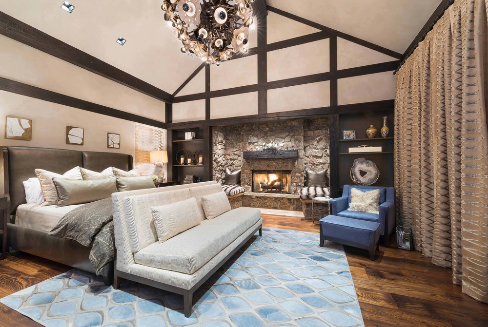 A beautifully designed master bedroom featuring a spherical starburst chandelier with layers of glass and metal discs.