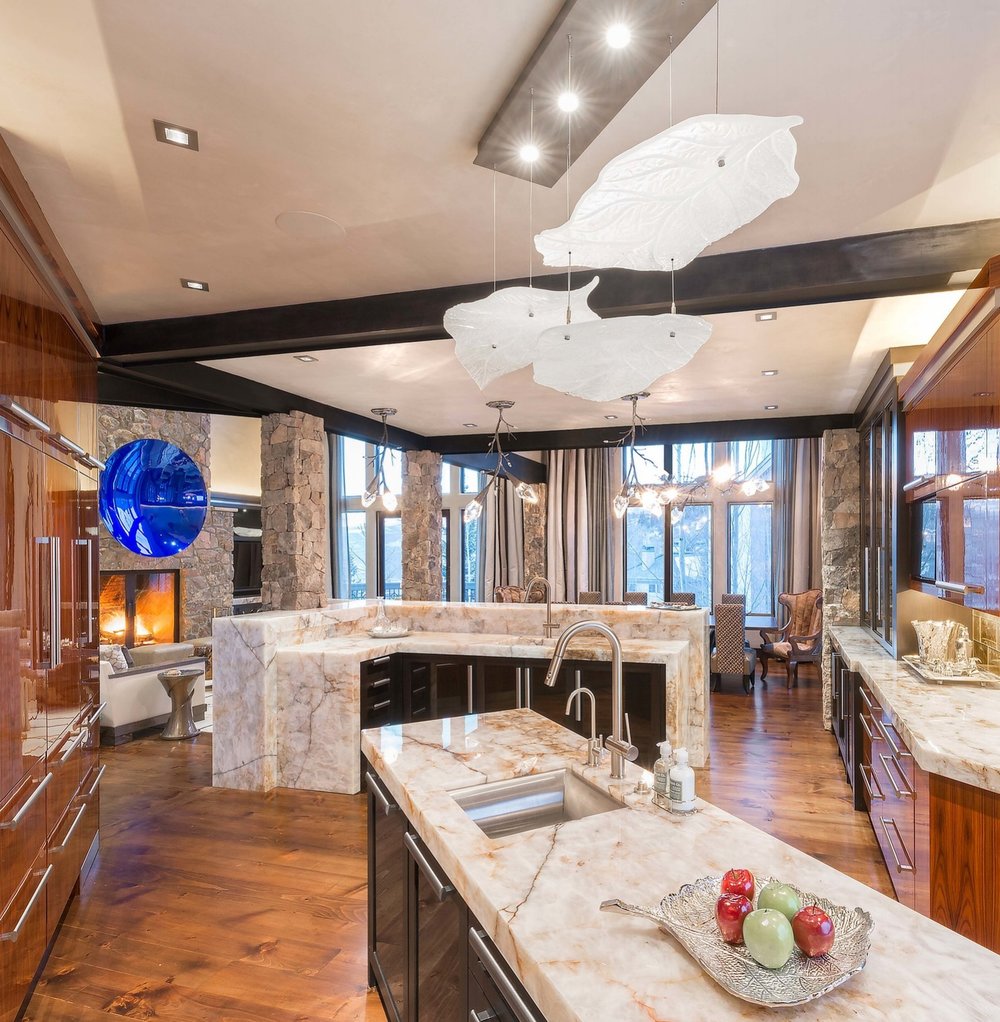 Large glass leaves cast from crystal are suspended and illuminated from above in this unique chandelier from Hammerton