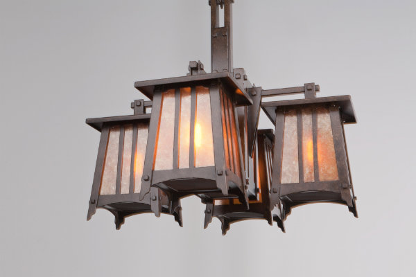 This custom Craftsman chandelier is crafted with mica glass and a dark bronze finish. You can certainly see the architectural inspiration from Greene and Greene -- the strong tapered sides and articulate horizontal lines give this fixture a bungalow feel, as well as sculptural prowess.