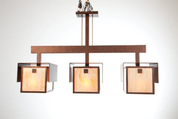 This unique suspension light, crafted from artisan glass with an antique copper finish, is stunning in its symmetry and simplicity. The fluidity and clean craftsmanship of this piece celebrates the essential ideologies of Arts & Crafts design.