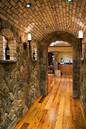  For the stacked stone hallway, interior designer Randi Skiffington chose a simple sconce design featuring an old world stem to enhance the room's European feel. 