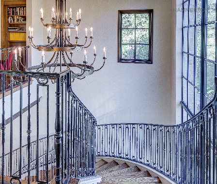 A graceful Chateau chandelier perfectly complements this stately European-style staircase. Architecture & interiors by Duvall Architects.