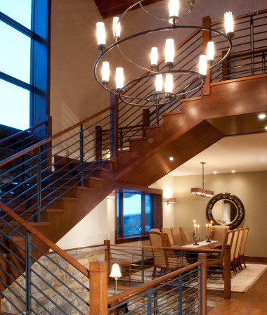 Clean lines in this Seriph chandelier quietly complement the spare railing of a contemporary staircase.