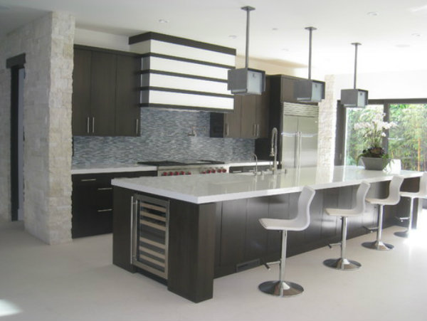  A trio of sleek pendant lights mirrors this contemporary kitchen's monochromatic color palette and clean architectural lines. 