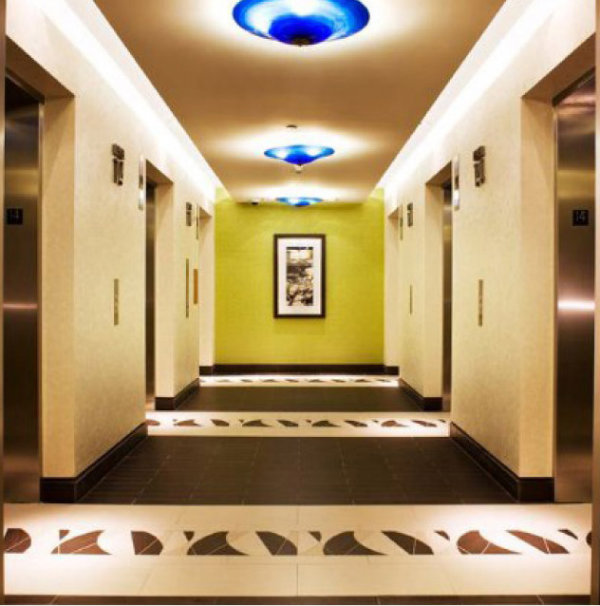 These diminutive yet impactful ceiling fixtures, featuring a vibrant blown Blue Cararra glass, make a bold statement in this hotel elevator lobby.