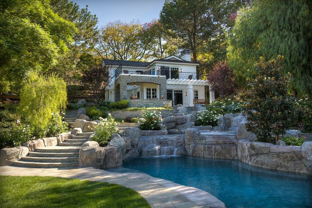 A backyard retreat to be jealous of featuring an impressive water feature and outdoor lighting by Hammerton
