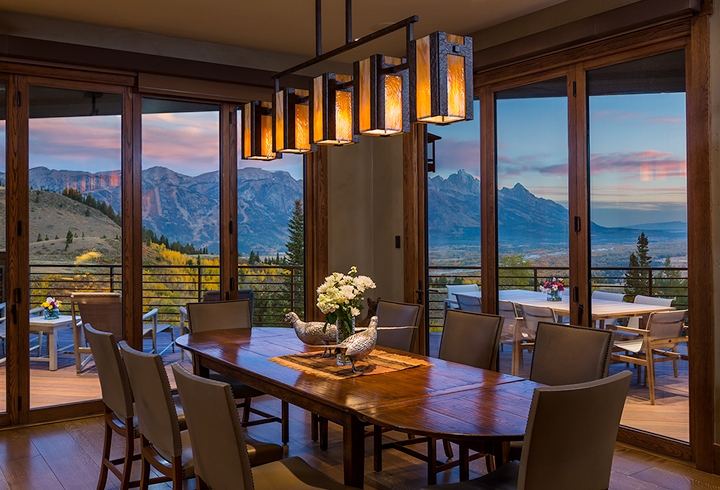 A custom Hammerton contemporary dining light in dark art glass and hammered steel enhances the sweeping postcard view of this Wyoming dining room | Trynity DeVries Interior Design | Bozeman, MT